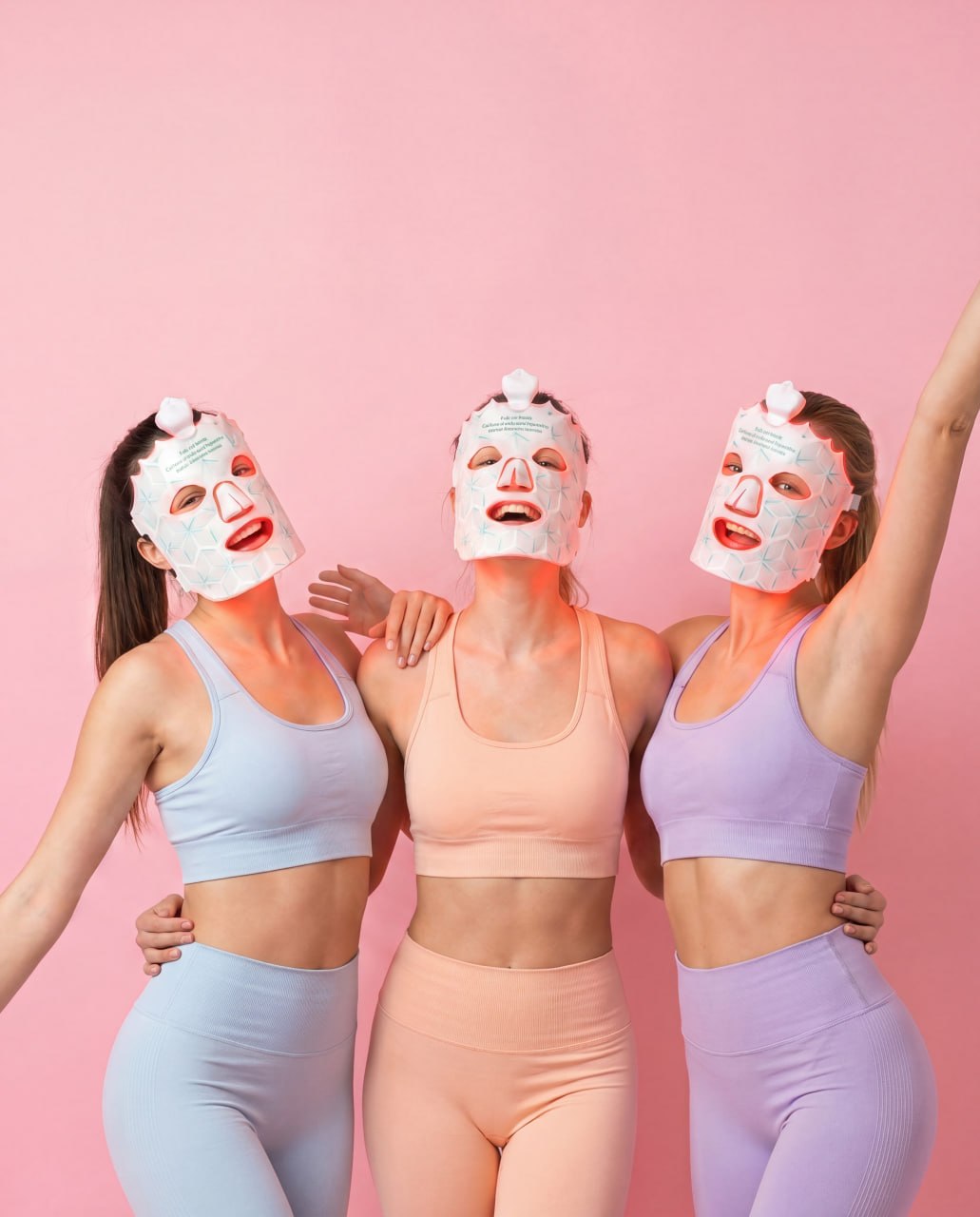 Three friends glowing together in Lumora LED light therapy masks